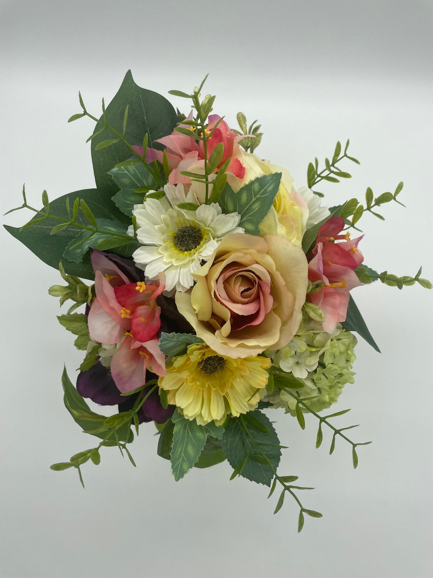 A mini bouquet set in an antique vessel.  Measures approximately 6" x 6" x 10" (vase included)