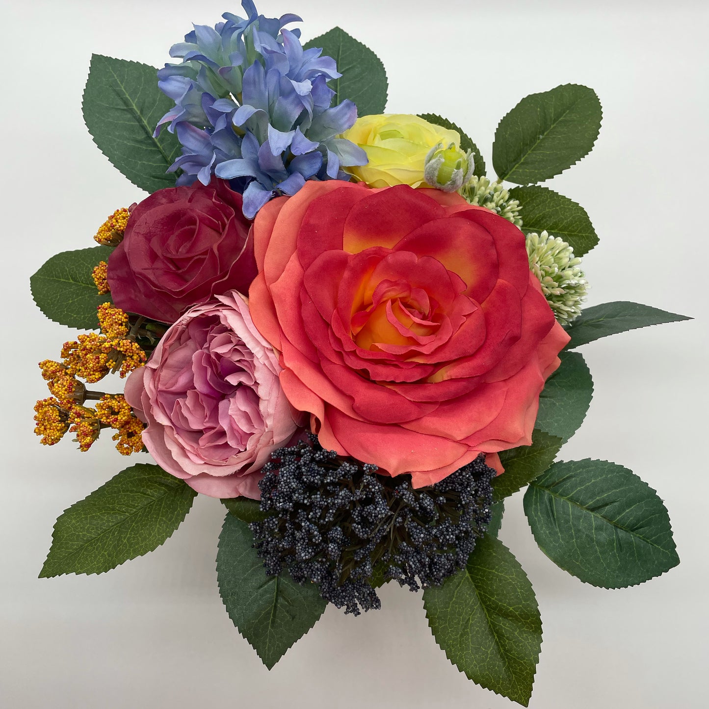 A colorful bouquet featuring blooms of the season. Set in a foam base so that you can transfer to your own favorite container. Bouquet is wrapped in a decorative burlap sack ready to gift or simply place in your space. Bouquet can vary depending on available seasonal blooms.  Measures Approximately 9"x 9"x 11"